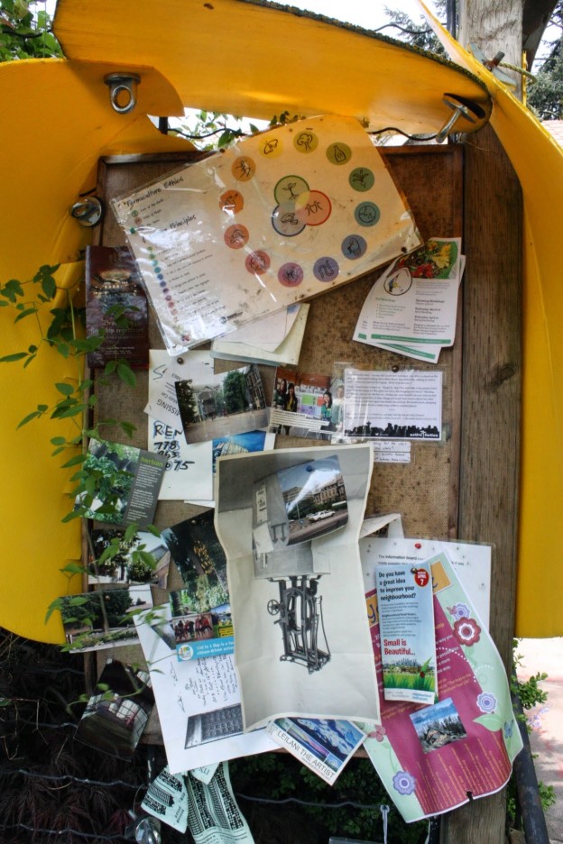 An outdoor corkboard covered with letters and photos